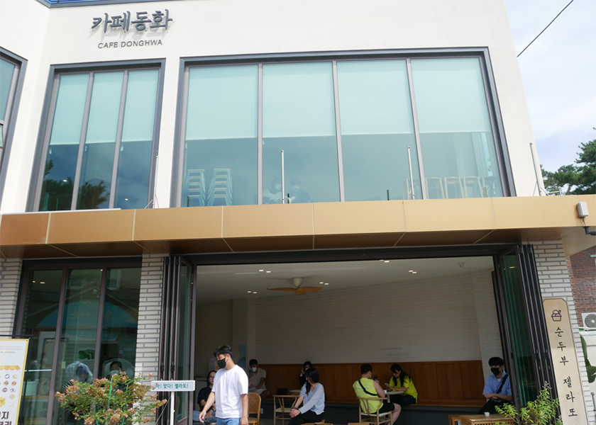 Cafe Donghwa 的外觀，人們在咖啡廳座位區。