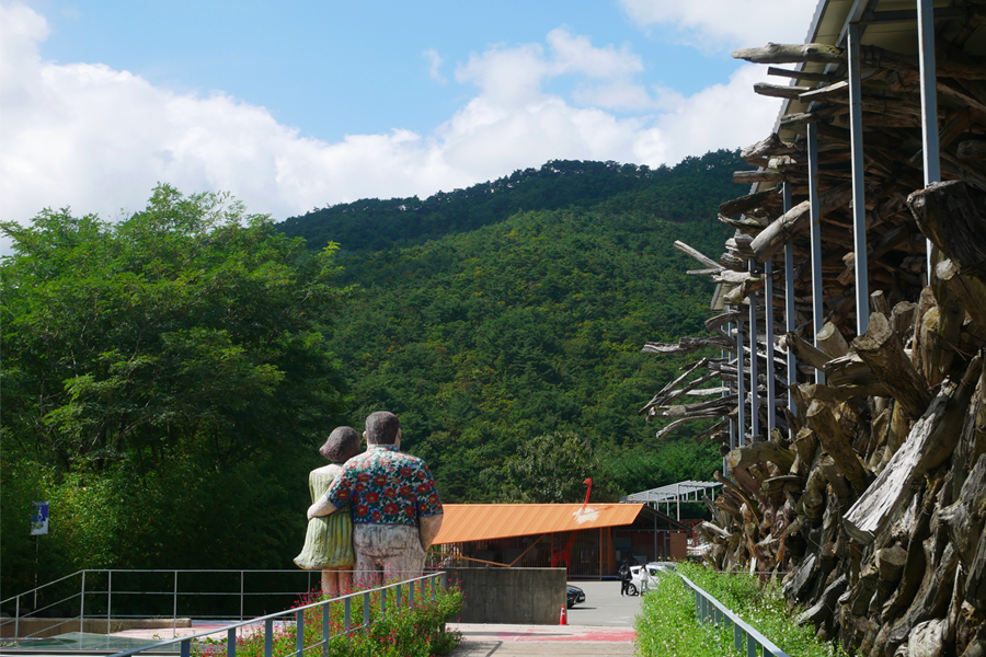 哈斯拉藝術村內的巨大可愛雕塑，雕塑面向著綠意盎然的山丘。