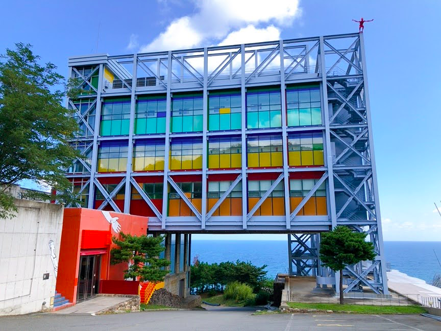 哈斯拉藝術村的現代化設計建築，五顏六色的窗戶以及遠處的東海海景。