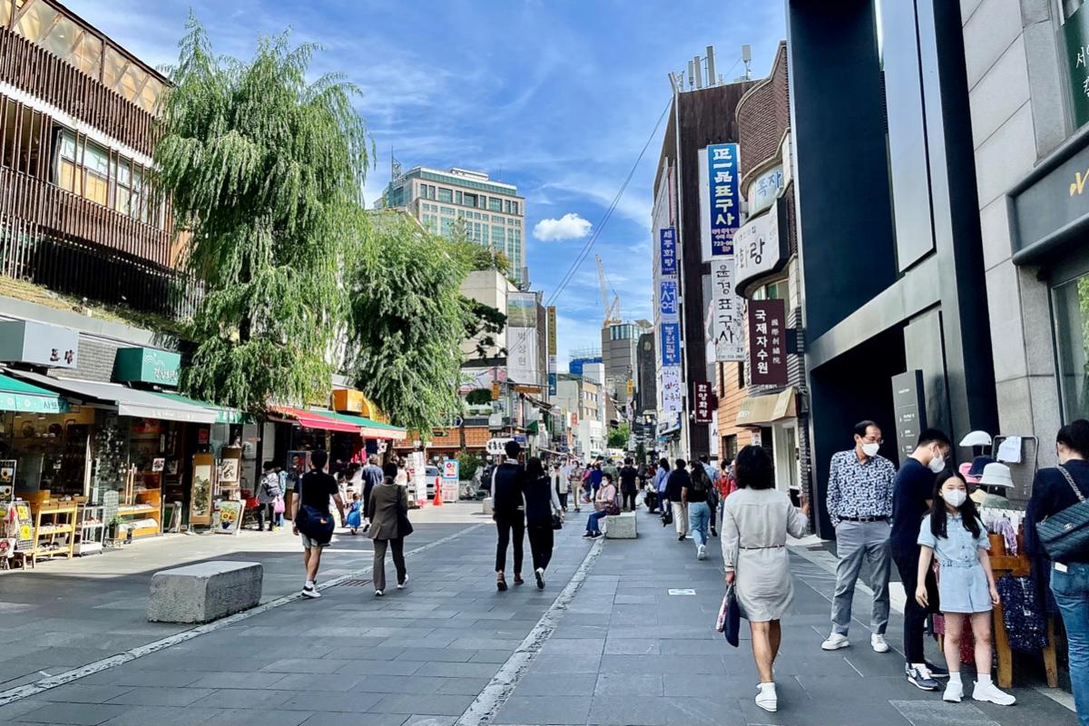 Rue d'Insadong un après-midi avec des boutiques et des visiteurs se promenant, sous un ciel bleu clair à Séoul.