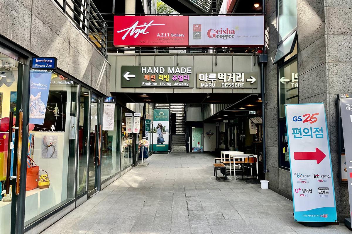 Vicinity of the Maru eating alley in Insadong, showing entrance to the GS25 and various shops, exemplifying the vibrant retail space.
