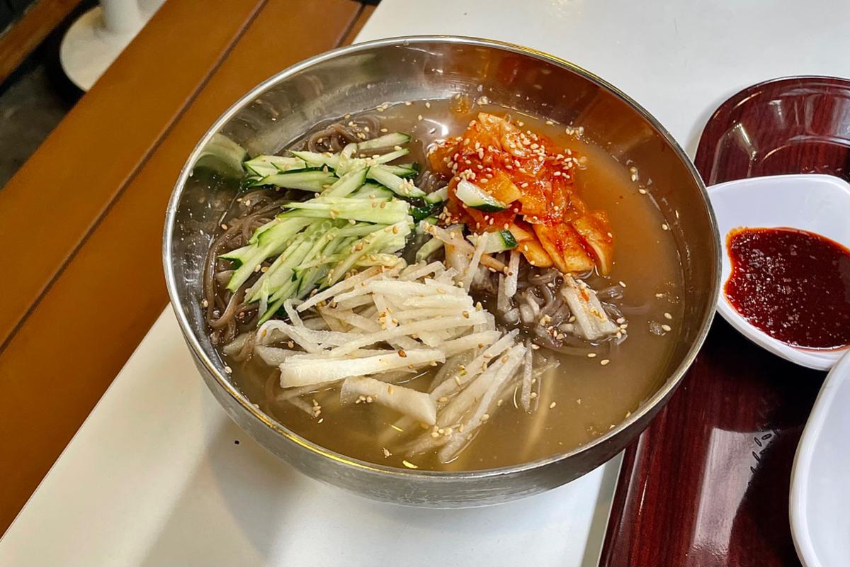 Nouilles de sarrasin froides dans l'eau de radis, un plat rafraîchissant servi au snack-bar Maru JaYeonSik Kimbap à Insadong, avec des légumes.