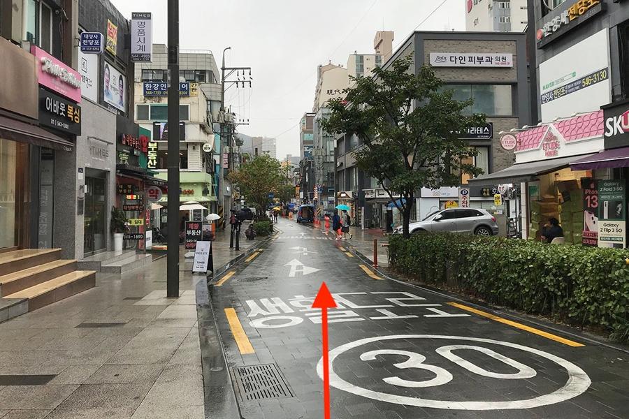 ภาพถนนภายในเมืองโซลที่ถูกถ่ายจากระดับสายตา บ้านร้านบริเวณนี้มีลักษณะสถาปัตยกรรมทันสมัยและดูสะอาดตา บรรยากาศเงียบสงบ