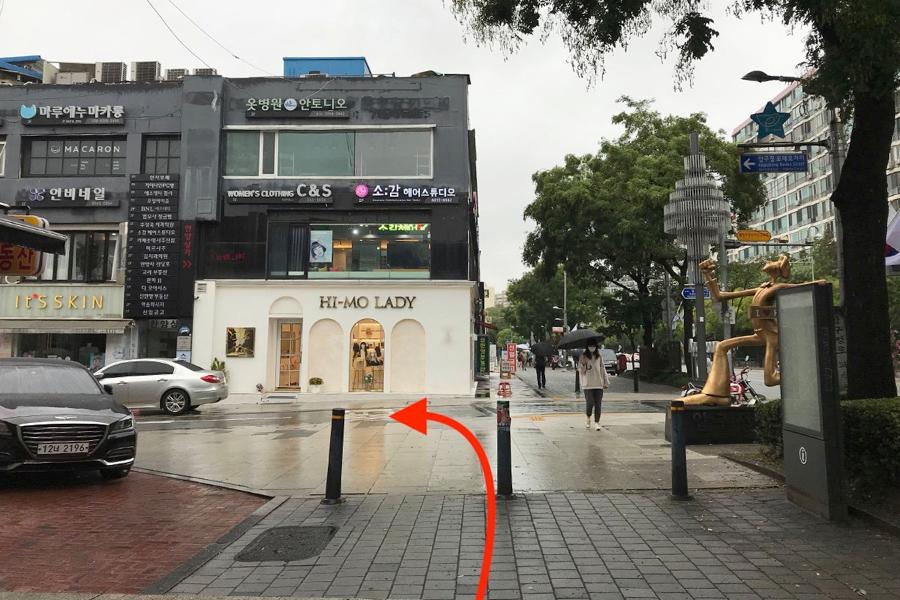 ภาพทางเข้าเลี้ยวเข้าซอยขณะเดินจากสถานี Apgujeong Rodeo ใกล้กับร้าน Hi-Mo Lady ในโซล บรรยากาศเมืองที่สดชื่นแม้ฝนตก