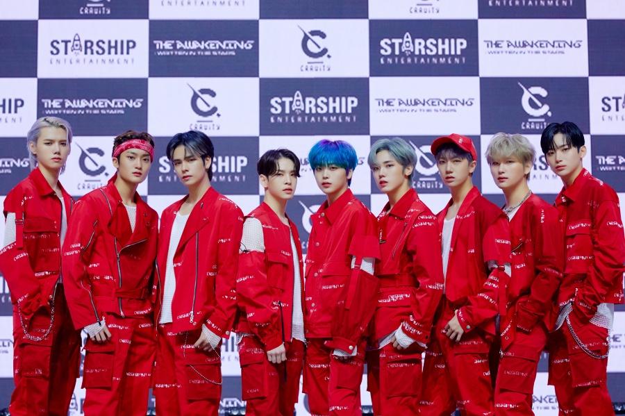 CRAVITY、グループメンバーたちが印象的な赤い衣装を着ている公式写真。STARSHIPエンターテインメントのロゴが背景に見える。