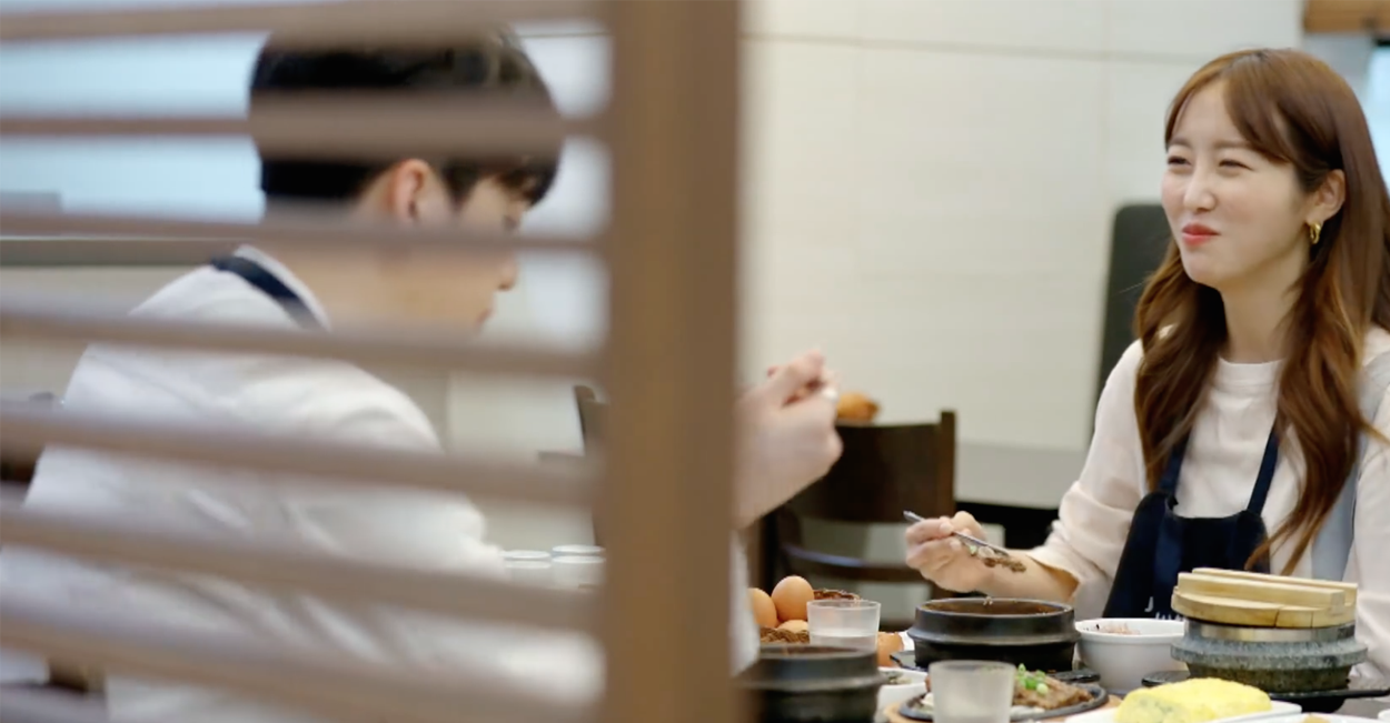 韓式餐廳的內景，客戶享用地道韓式煲仔鍋，周圍為現代木質裝潢，增添暖意氛圍。