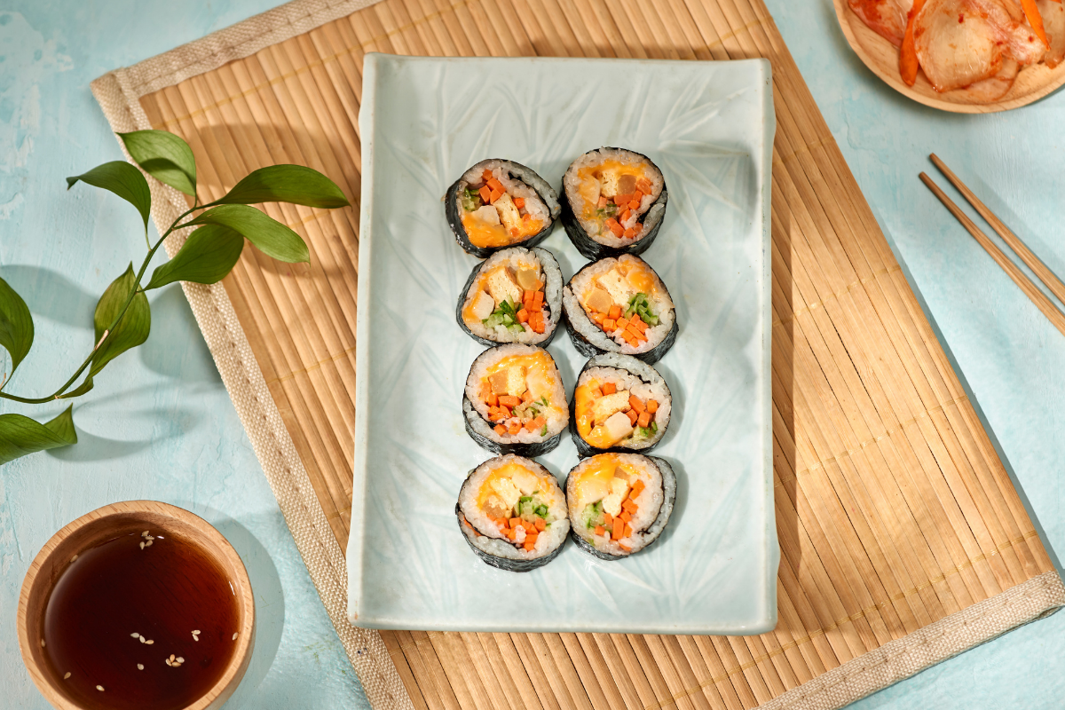 Kimbap là món cơm cuộn rong biển đặc trưng của Hàn Quốc với các nguyên liệu như cơm, rau củ, và thịt hoặc trứng, được cuộn trong lá rong biển.