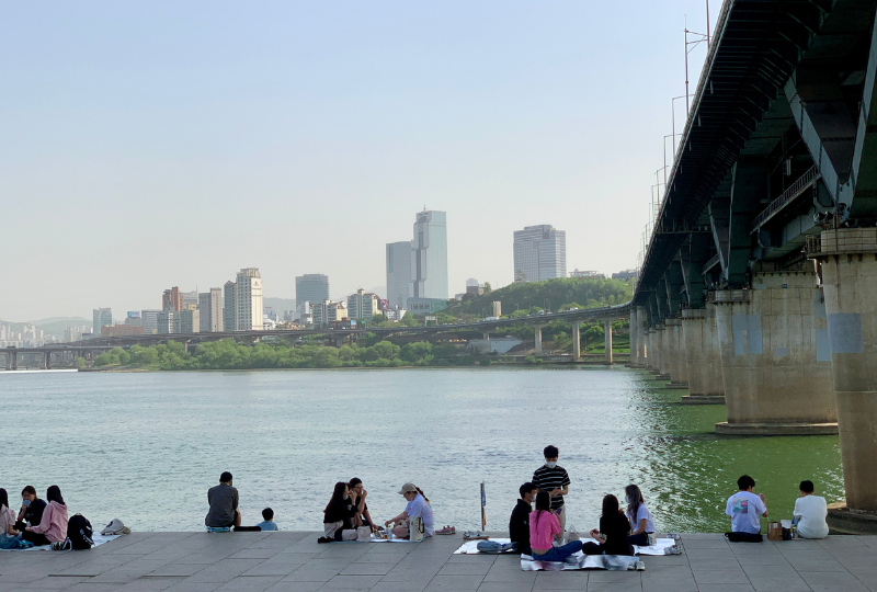 纛島漢江公園的河邊風景，市民們沿著河畔休憩，享受首爾城市中的自然景觀