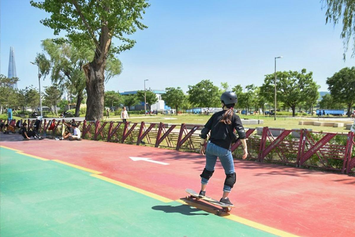 seoul korea ttukseom han river park, girl skateboarding