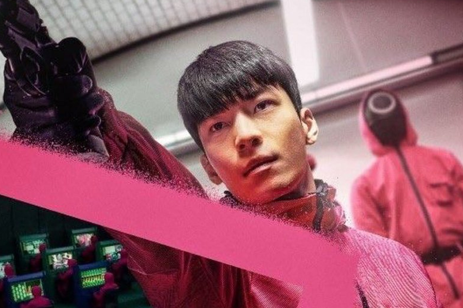 《魷魚遊戲》中一位持槍者身著粉紅色服裝，站在控制中心，影集場景來自Netflix原創。