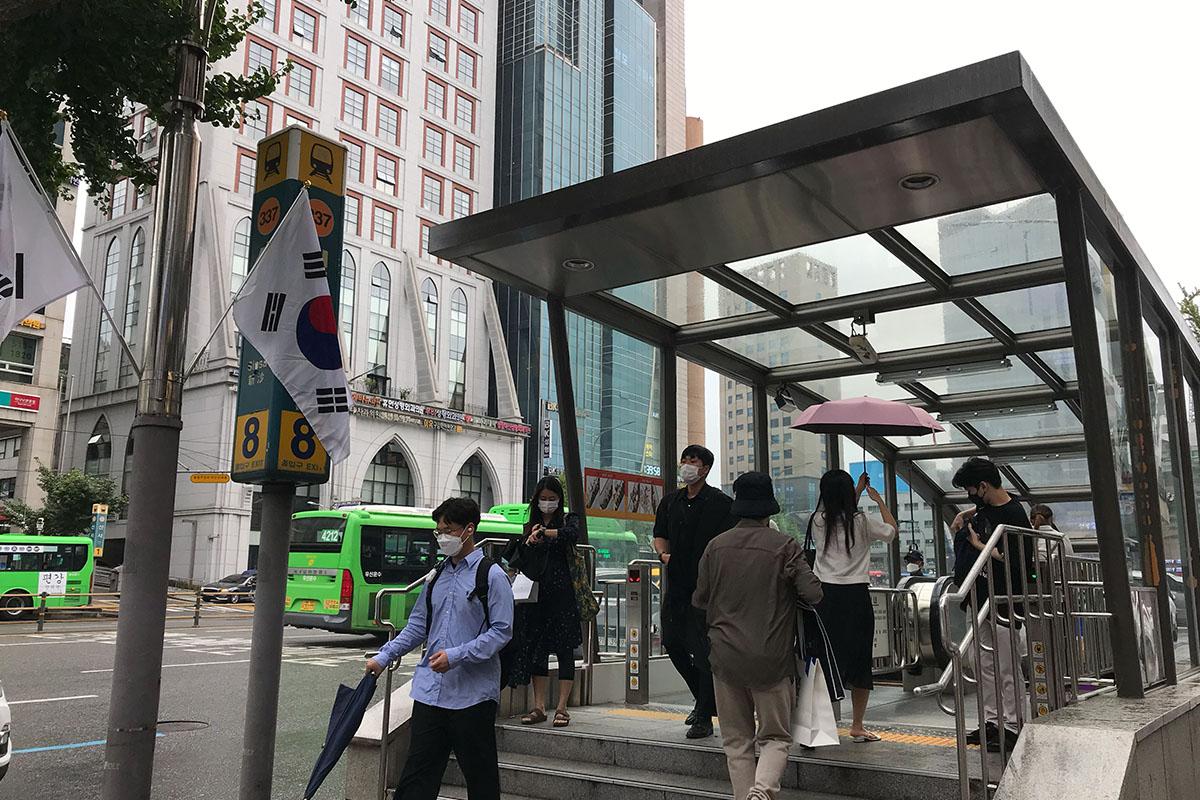 สถานีรถไฟฟ้าชินซา ทางออกที่ 8 ในกรุงโซล มีผู้คนกำลังเดินออกจากสถานีท่ามกลางเมือง