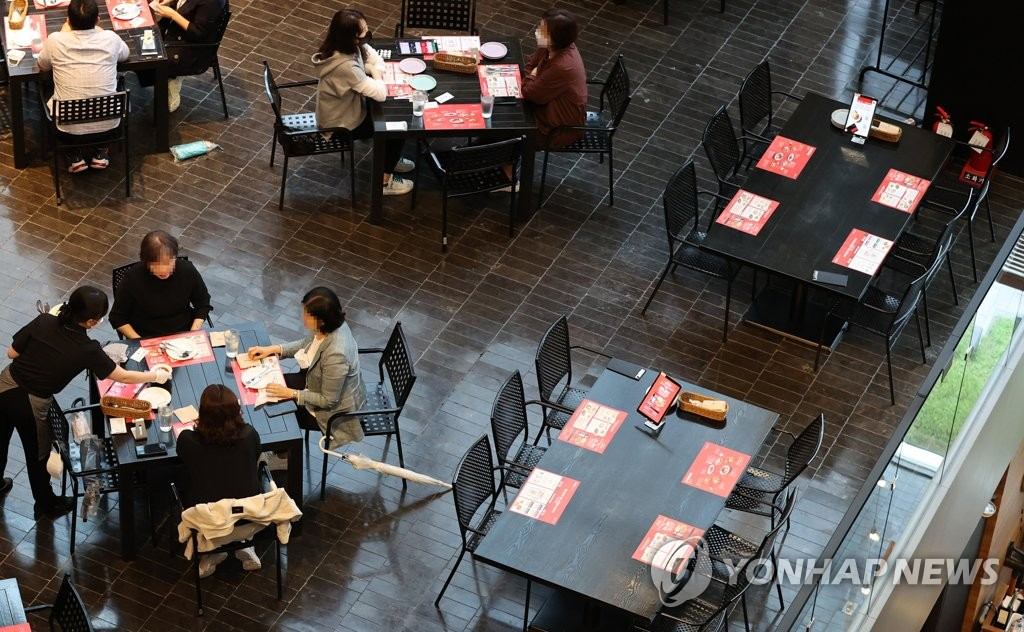 韩国餐厅内顾客就餐情景，反映新冠疫情下的社交距离措施