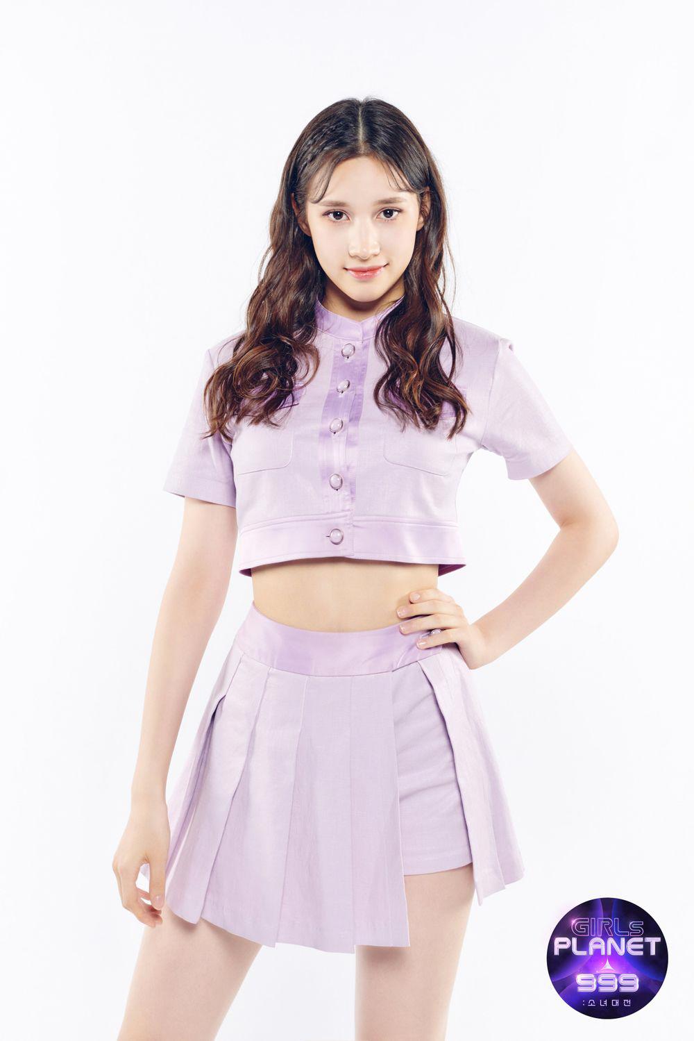 Kep1erのメンバーであるヒュニン・バヒエがMnetのオーディション番組『Girls Planet 999』に出演中の写真。番組ロゴ付きで、紫色の衣装を着ている。韓国で活動するガールズグループKep1erが国際的な注目を集める場面を示している。