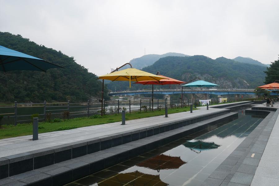 艮峴觀光地的河岸景色，設有桌椅供遊人觀賞壯麗的天然風光。