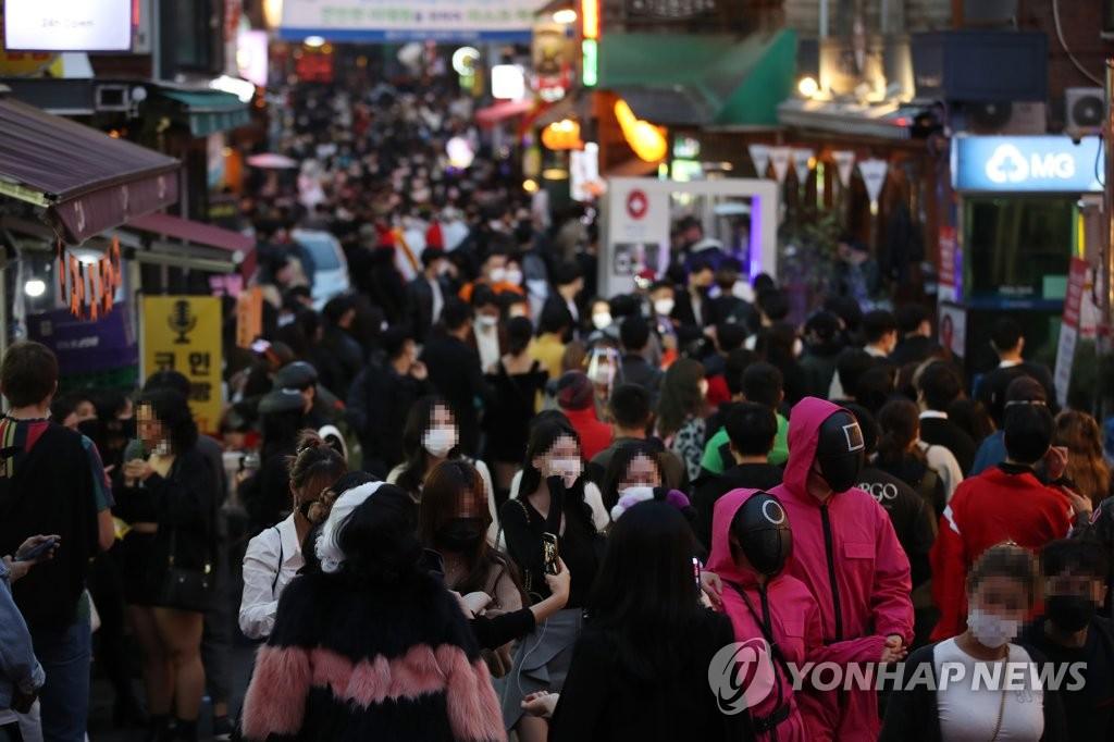 写真に写る梨泰院の通りでハロウィンイベントに参加するため行き交う人々。コロナ19防疫対策が問われる状況。