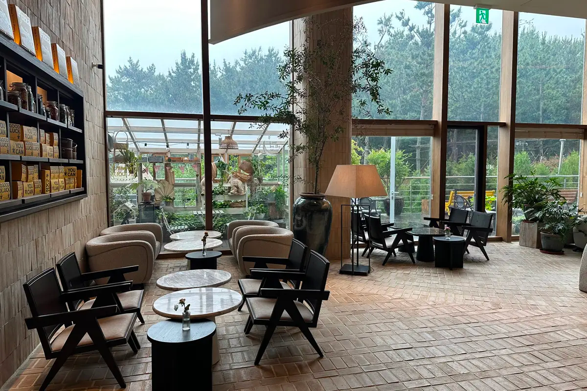 大满月餐厅咖啡区域，四周环绕玻璃窗户，现代化的舒适椅子设计与户外风景相映成趣。