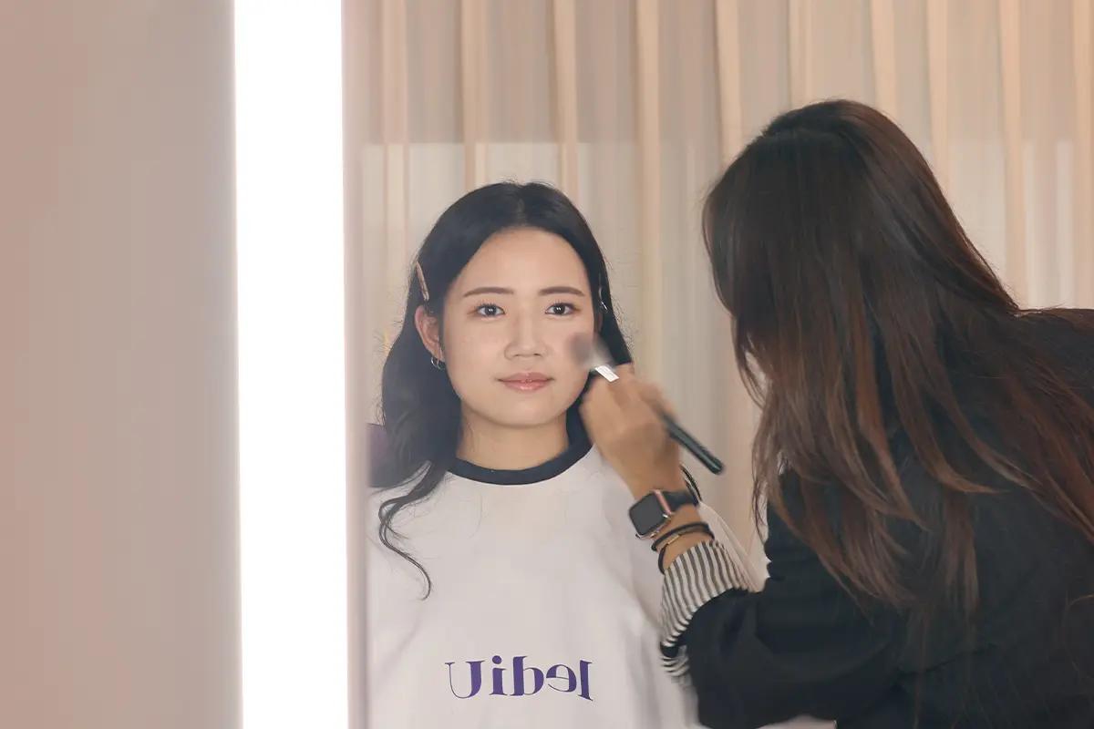 การแต่งหน้าแบบมืออาชีพที่ LediU ฮงแดซึ่งช่างกำลังใช้แปรงบนใบหน้าของลูกค้า