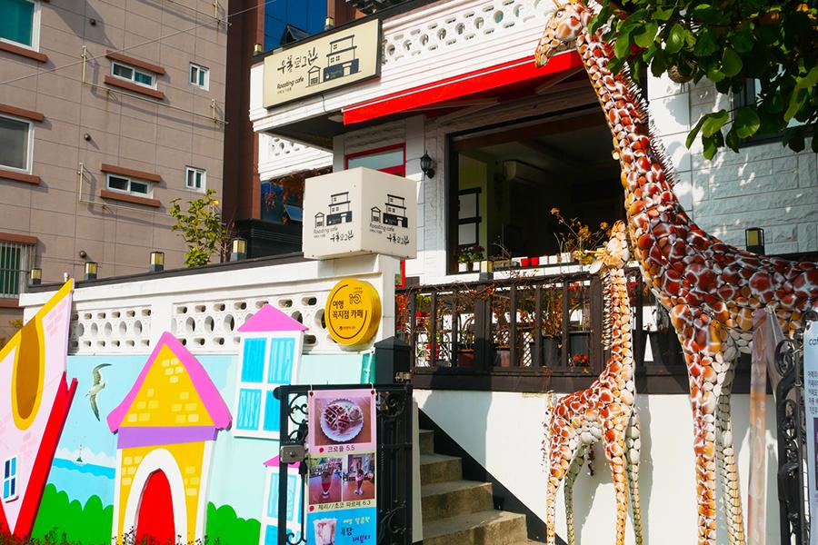 松月洞童話村內的卡通主題餐館，外牆裝飾是海豚和粉色的海報。