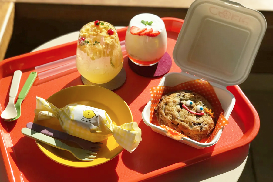 Cafe Skon在韓國首爾展示的甜點與飲品，餐具擺放在紅色託盤上，陽光明媚的露臺場景