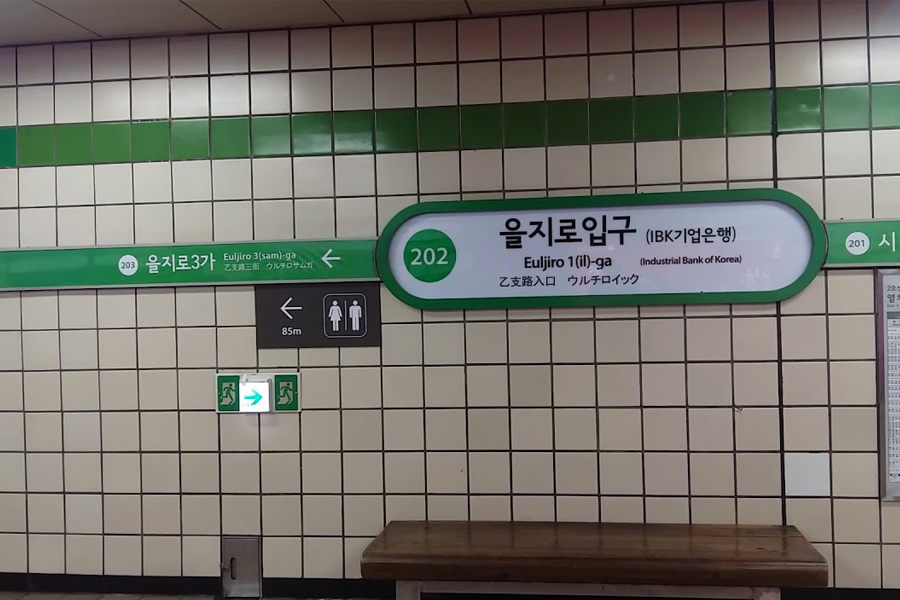 Euljiro-1(il)ga地鐵站的方向指標，顯示前往乙支路3街和乙支路入口的路線信息，便利的地鐵交通讓乙支路區域與首爾各地緊密連結，交通指南提供旅行者精確的地鐵搭乘時間和換乘建議。
