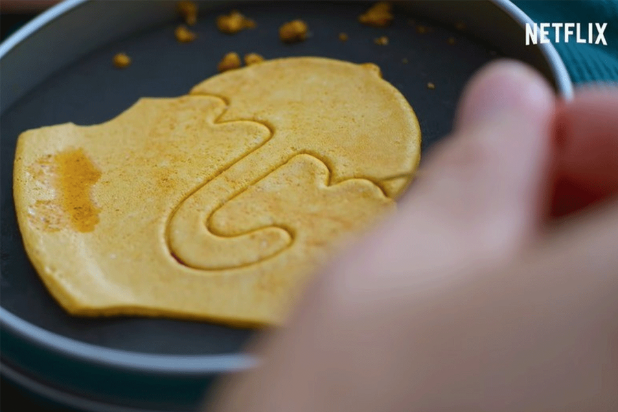 正方形的韓國傳統椪糖，上面刻有圖案，置於黑色背景之上。