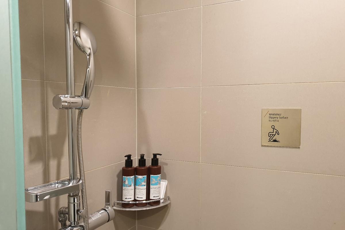 The shower fully-stocked with hair products and soap.