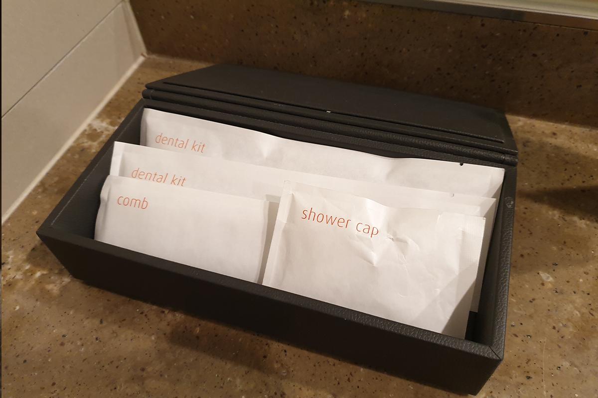 A box filled with individually-wrapped toiletries in the bathroom.