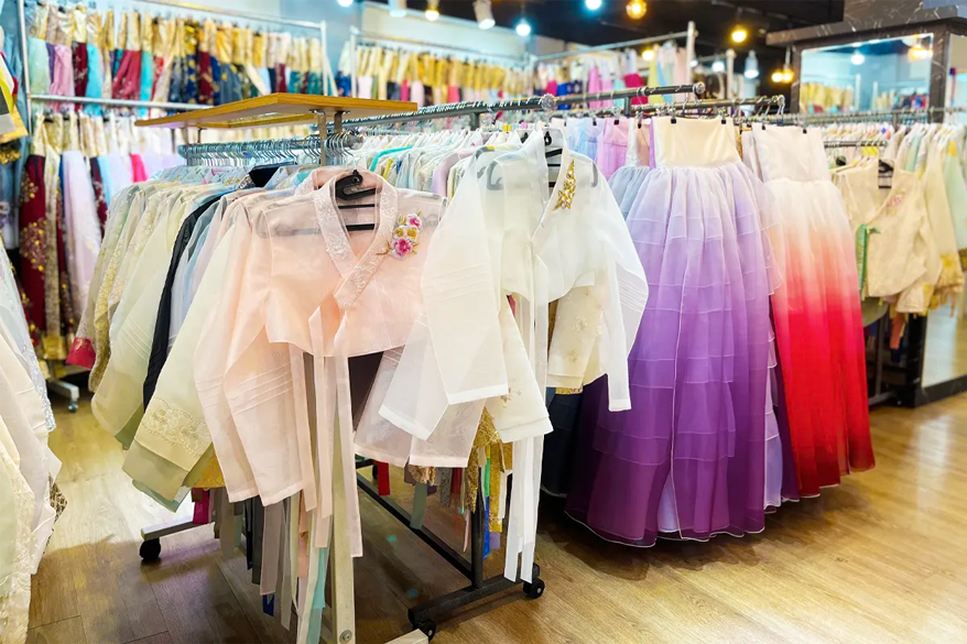 公主韩服店内展示的色彩丰富的传统韩服，包括白色外套和紫色渐变的裙子。