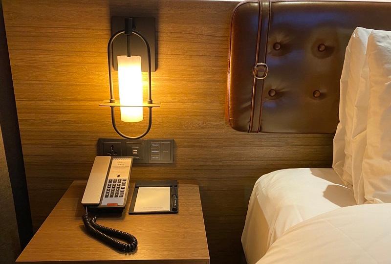 メルキュールホテル弘大のベッドサイド。温かい照明が配置され、リラックスできる空間。