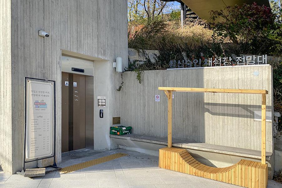 昌信洞崇仁采石场展望台的入口,有电梯和木制的长椅,为游客提供便捷和舒适的服务,展示出复古的工业风格。