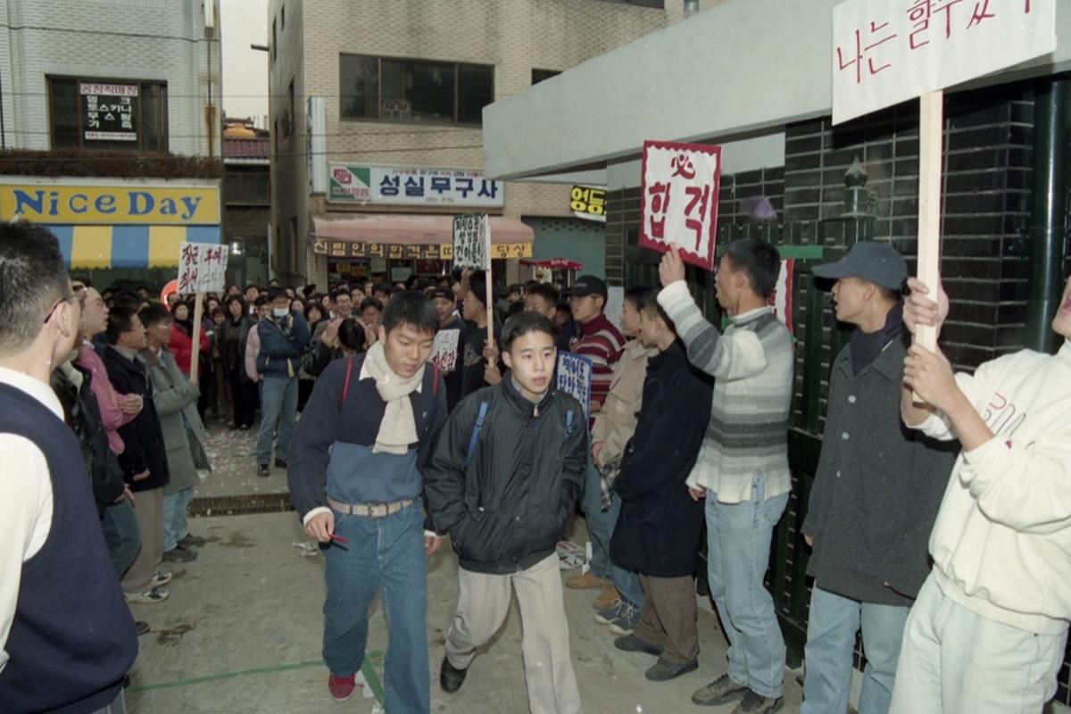 韩国修能考试期间，考生在教室内认真考试。图中可见考生们坐在桌前聚精会神地回答试卷。来源：연합뉴스