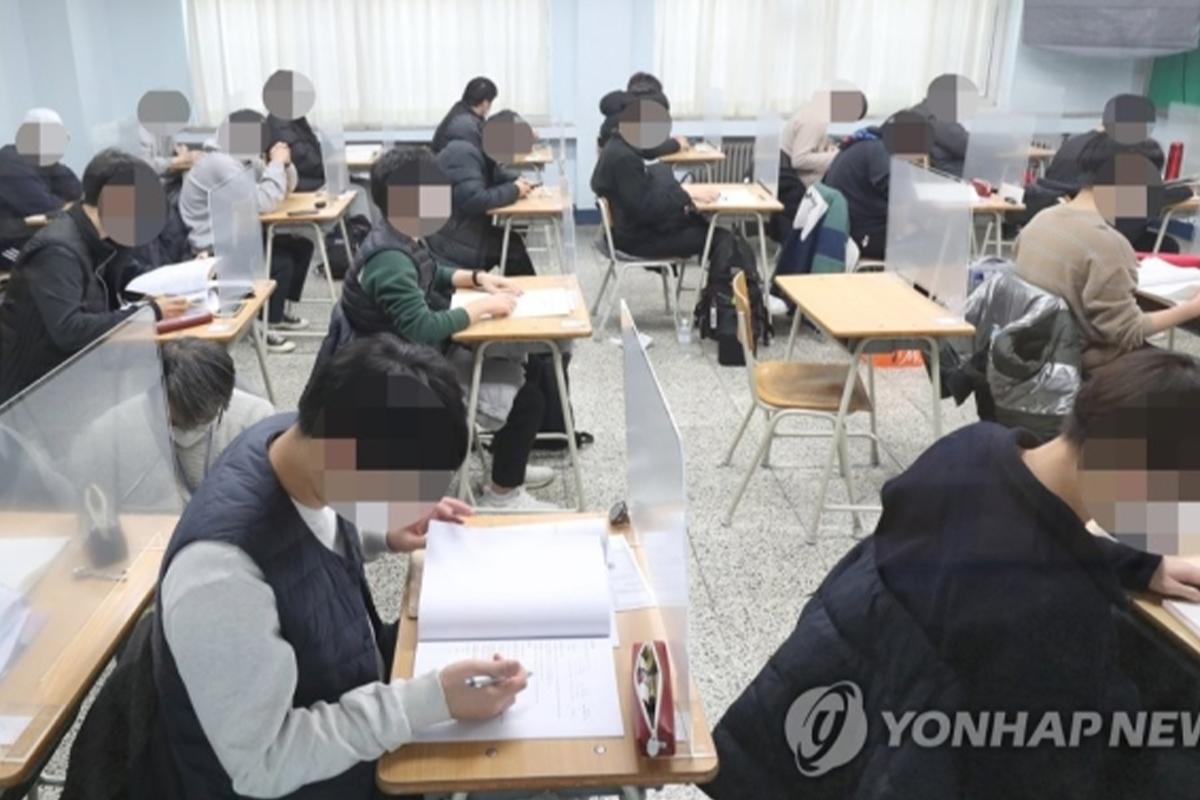 韩国修能考试期间，考生们在室内紧张地应考。所有考生分散坐在课桌前，各自埋头答题。来源：연합뉴스