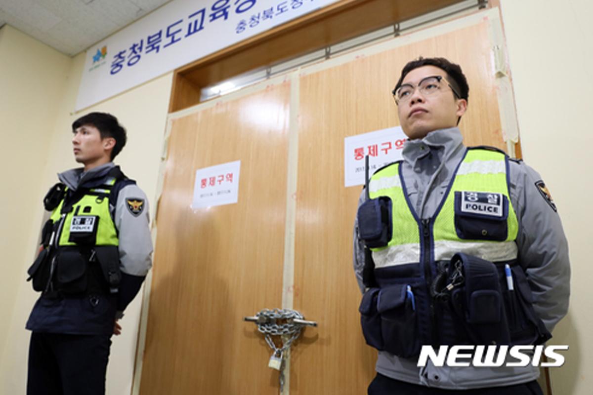 修能考试期间，大巴在夜晚载送出题委员至指定地点。大门口有保安进行看守。来源：국민일보