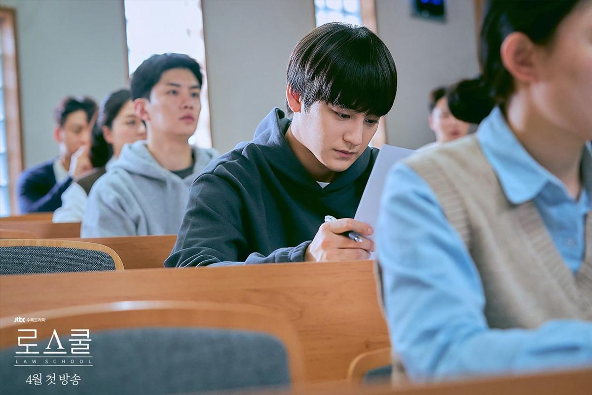 Sinh viên nam học giỏi đang ngồi học trong lớp học.