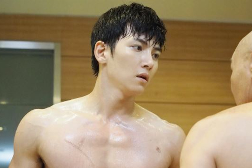 身材健壯的男子裸露上身，面部模糊，背景為木質色室內場景。