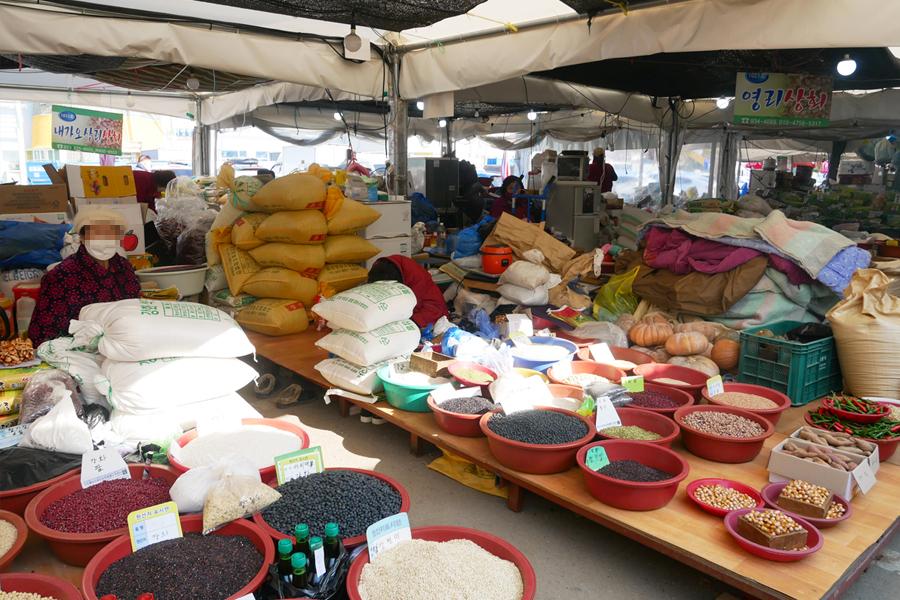 강화풍물시장의 실내 – 다양한 농산물과 해산물을 판매하는 상인의 모습