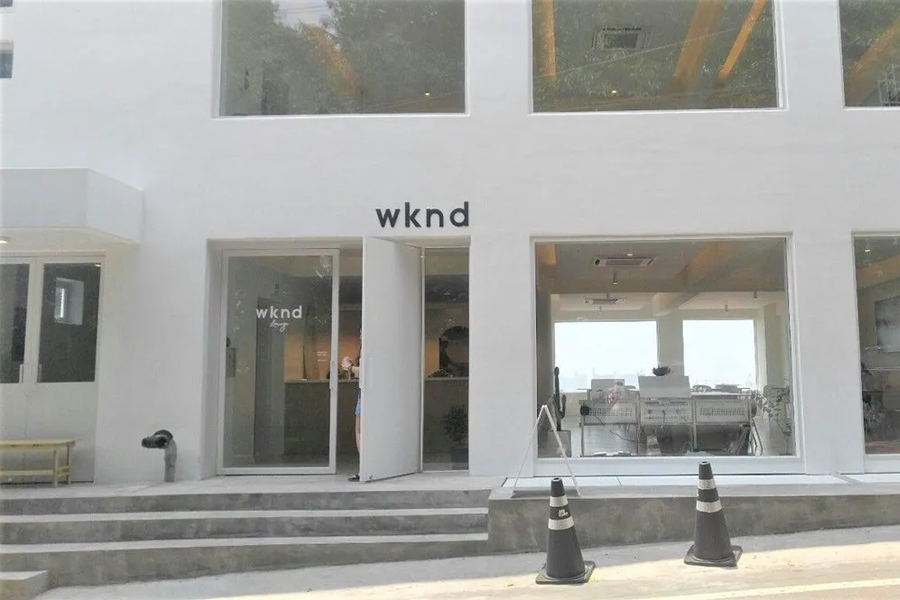 Minimalist exterior of wknd lounge cafe in Incheon, characterized by its sleek white design and large front windows.