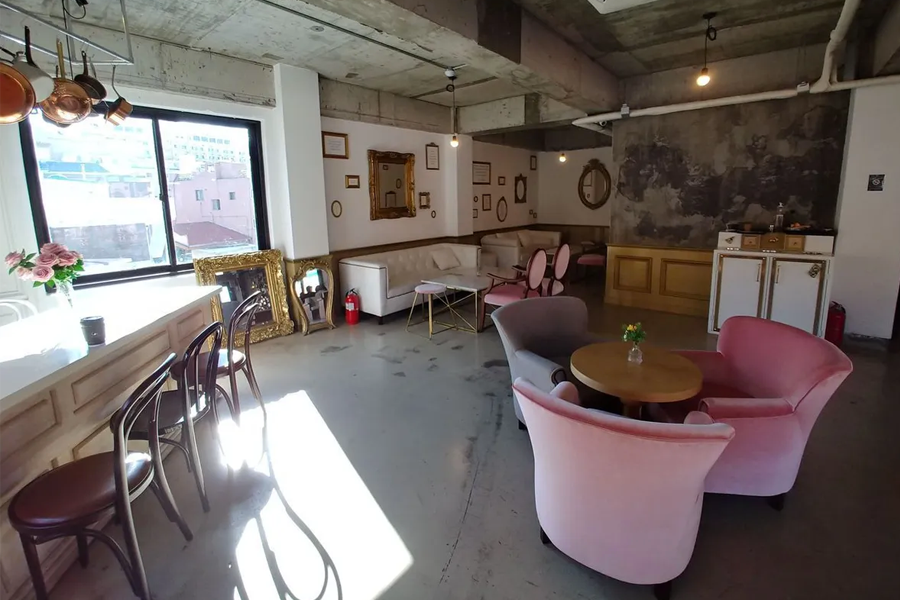 Interior of C27 Cheesecake & Coffee in Incheon, offering a cozy, eclectic aesthetic with various seating arrangements.
