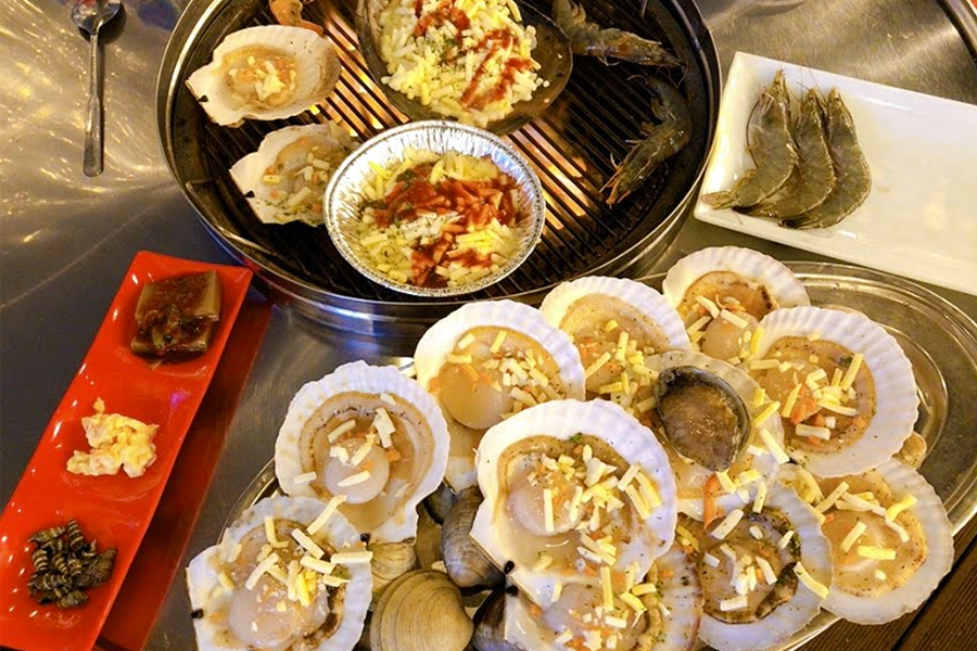 Grilled shellfish platter with clams, scallops, and shrimp, served at Dalbit Shellfish Grill in Wolmido, Incheon, South Korea.