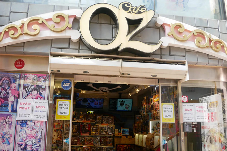 Exterior of OZ Cafe in the Songwol-dong Neighborhood, Incheon, featuring anime-themed exteriors and colorful signage.