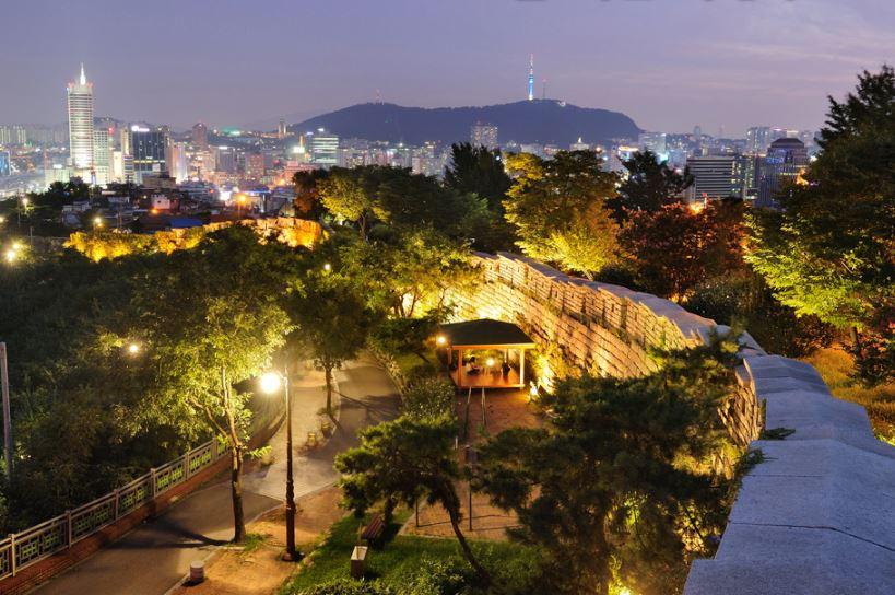 ソウルの中心部に位置する駱山公園からの夜景。照明で照らされた城壁が美しいコントラストを描き、広がる都市の灯りと共に見える。
