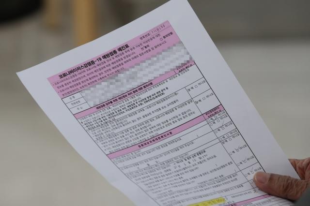 ソウル恩平区チョング聖心病院で3次ワクチン接種の予診票を持つ市民