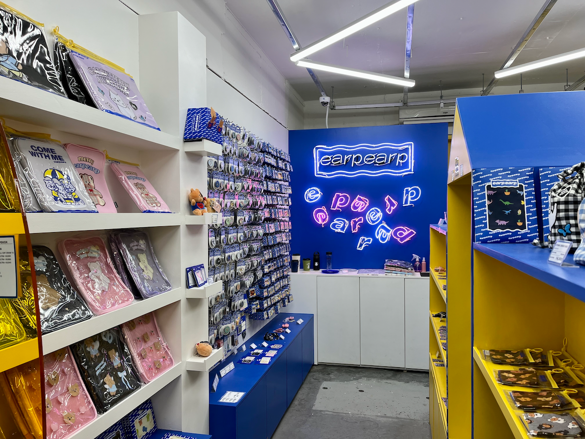 Interno colorato e stiloso del negozio earpearp a Songridan-gil, Seoul, con vivace decorazione blu e gialla.