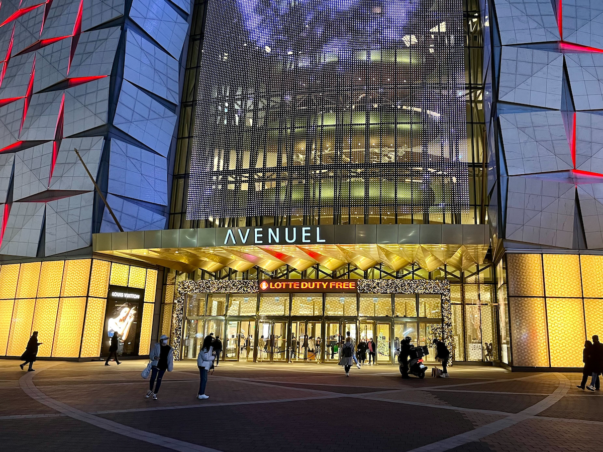 Facciata del complesso duty free Avenuel all'interno del Lotte World Tower, Seoul, illuminata di notte.