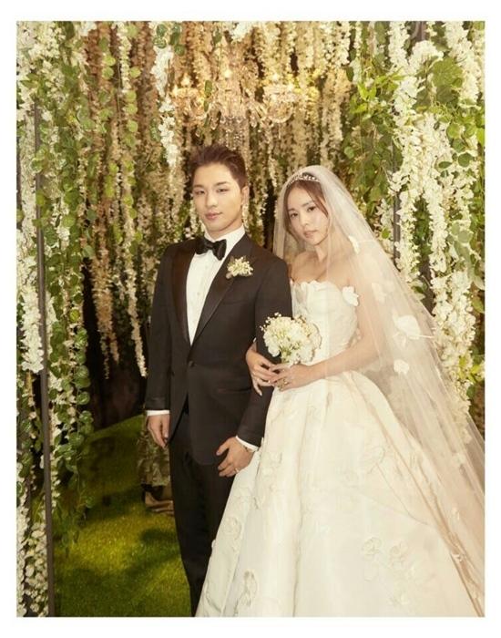 BIGBANGのSOLとミン・ヒョリンの結婚式の写真。新郎新婦の姿が華やかな装飾の中にあり、フォーマルなウェディングシーンが特徴的です。