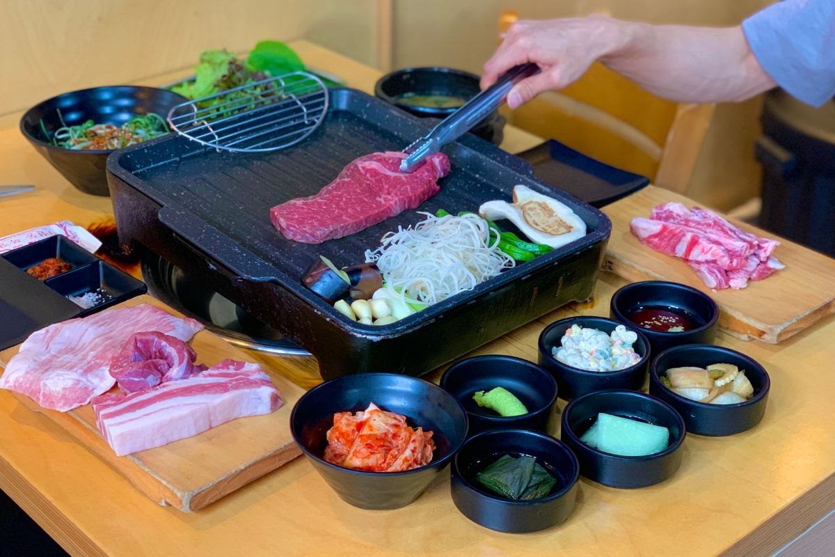 韓国料理レストランの焼肉セット、プレートに載った新鮮な牛肉と多様な野菜の盛り合わせ - 益善洞（イクソンドン）牧場