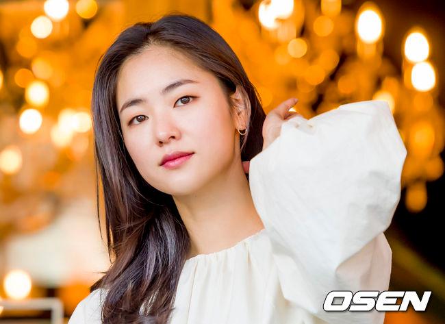 美しいシャンデリアの前で白い女性用トップを着た韓国女優チョン·ヨビン。雑誌やドラマの撮影中に見られる典型的なイメージ。