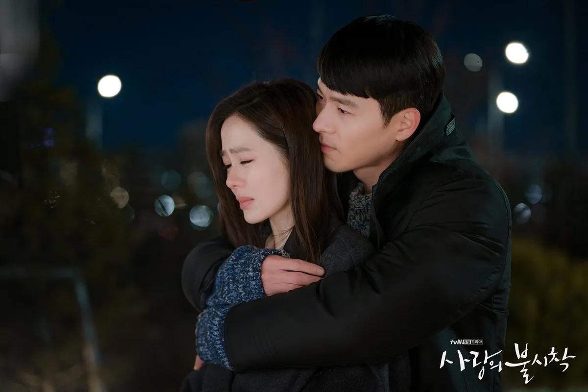 韩剧《爱的迫降》剧照，两个人紧紧拥抱，背景是夜晚的城市灯光