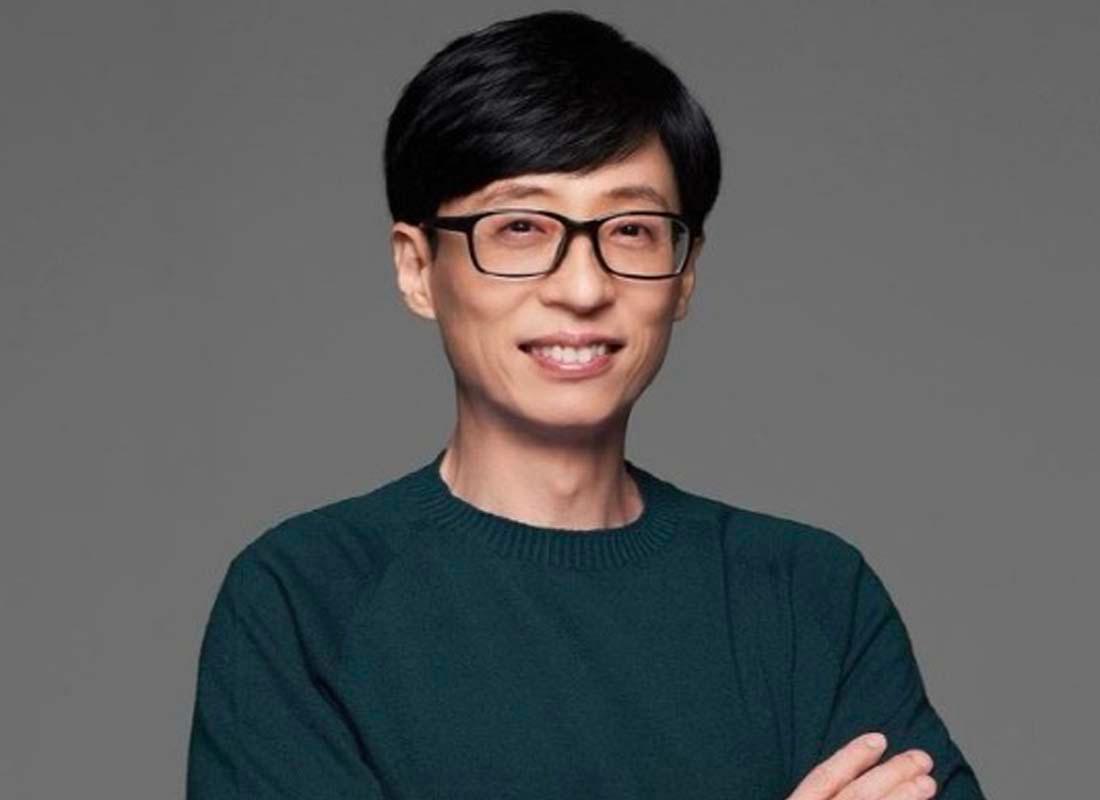 ผู้ชายในเสื้อกันหนาวสีเขียวเข้มยืนด้วยแขนไขว้ ดูมีท่าทางที่หนักแน่นและมั่นใจ โดยเป็นภาพที่เกี่ยวข้องกับข่าวสุขภาพและวงการบันเทิงเกาหลี