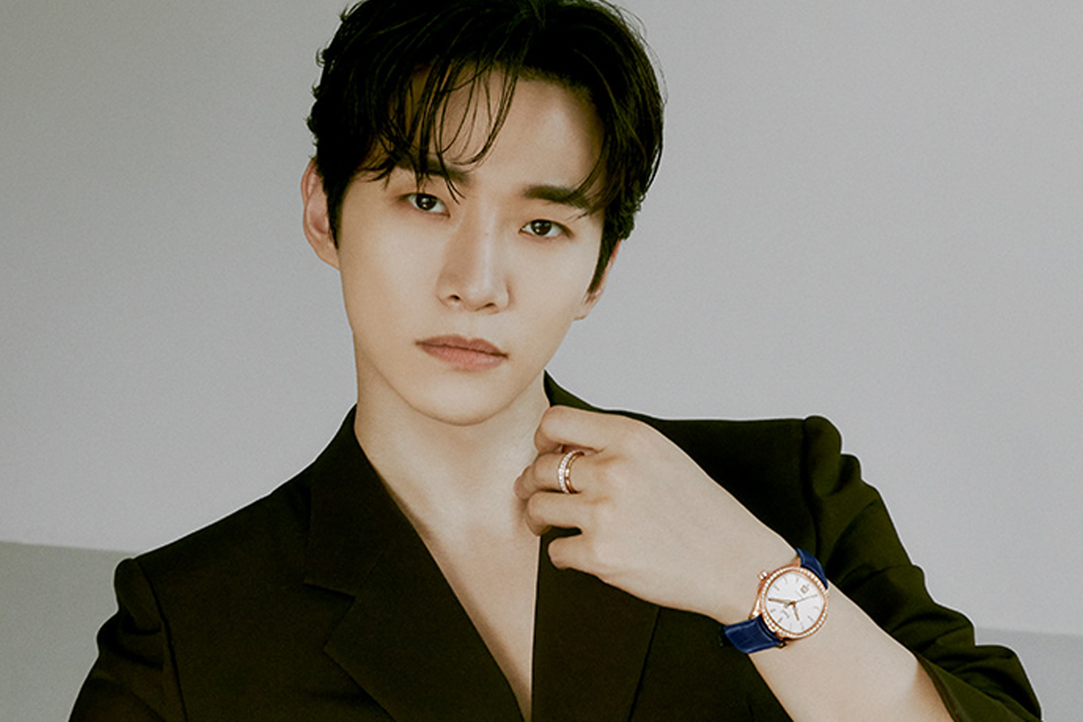 2PM 俊昊 的半身肖像圖, 穿著黑色外套, 手部佩戴著時尚的手錶, 營造出優雅的氛圍